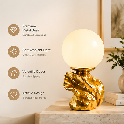 Close-up of the sculptural gold-tone lamp base showing flowing folds and reflective texture