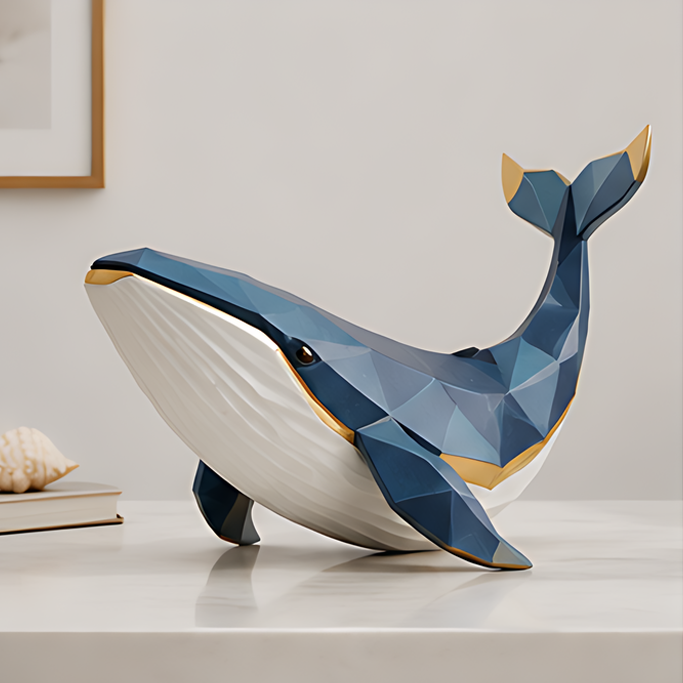 Blue and white geometric whale sculpture with gold-tone accents, extended fins and a raised tail on a light tabletop