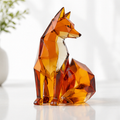 Amber orange faceted fox figurine with a clear-looking chest and curled tail on a light tabletop