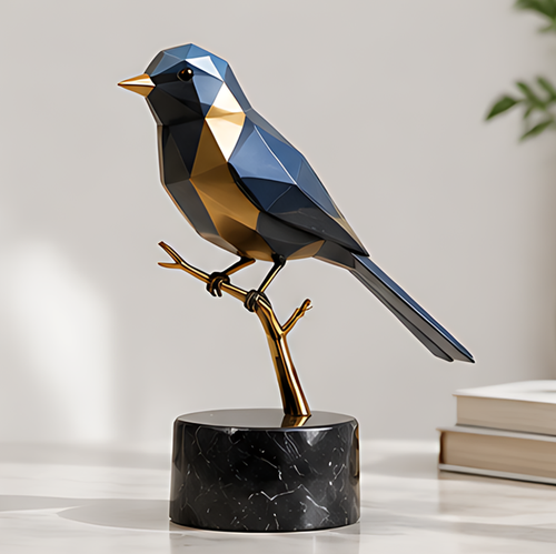 Blue and gold-tone geometric bird sculpture perched on a gold-tone branch above a black veined cylindrical base