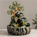 Tree design tabletop fountain with green leaves, gold-tone trunk and two cascading bowls above a dark textured basin